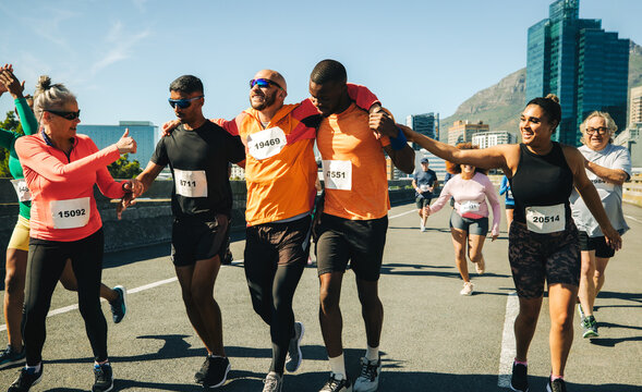 Teammates help injured runner during city marathon race