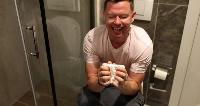 A man experiences a whirlwind of intense emotions while gripping a cup in a cozy, intimate bathroom setting