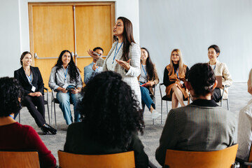 Business event with diverse group learning in workshop setting led by energetic speaker