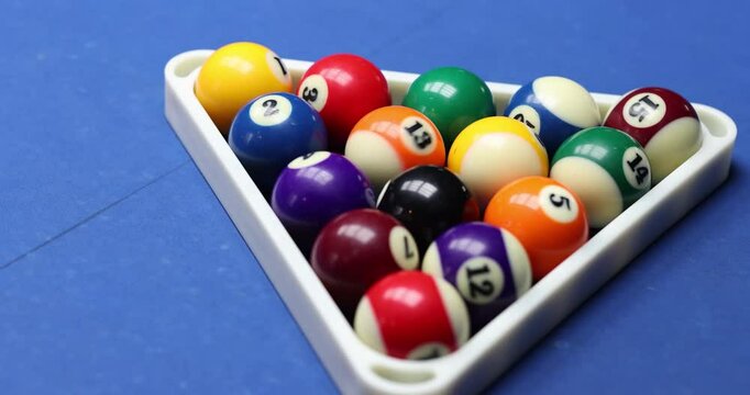 A vibrant collection of colorful pool balls, majestically arranged in a neat triangle, ideal for billiards enthusiasts