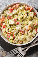 Pesto Chicken Salad with celery, onion, pepper and almond flakes closeup on the table. Vertical top view from above