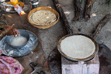 Poor woman in village cooking food. Indian village women pilgrims cooking food traditional. Bread from the village
