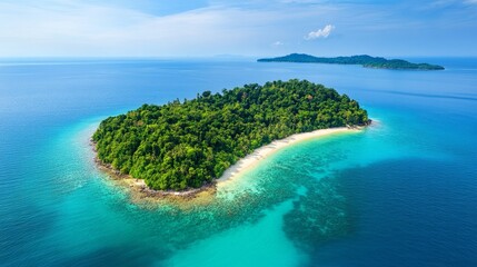 Fototapeta premium A densely forested island surrounded by turquoise waters, as viewed from above 