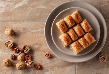 Baklava with walnuts on a beige plate.