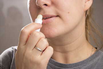 Close up of a caucasian woman holding a hygienic lip balm stick for lips 