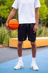Naklejka premium Man in a white tshirt and black shorts with a ball in hands