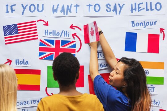 Diverse group learning languages. Multicultural students explore greetings. Flags and languages. Language learning and cultural exchange. Diverse group, languages, flags. Education and knowledge.