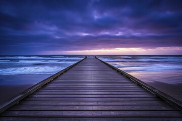Obraz premium Serene wooden pier stretches into vast ocean under dramatic, colorful sky at dusk.