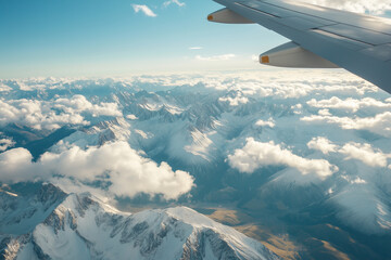 Fototapeta premium Stunning aerial view from an airplane window showing vast snow-covered mountains piercing through a sea of clouds. 