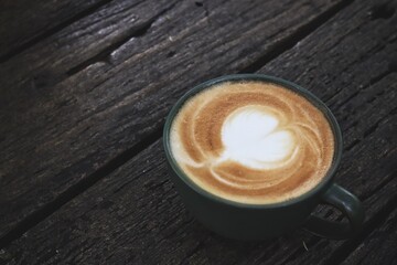 Latte art coffee cup on wooden table