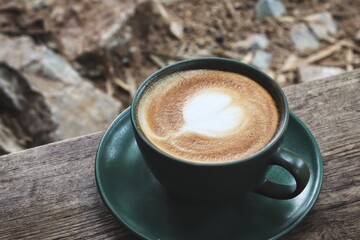 Latte art coffee cup on wooden table