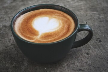 Fototapeta premium Latte art coffee cup on wooden table
