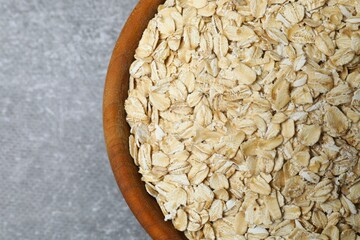 Composition with oatmeal flakes on gray background. Cooking breakfast