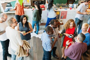 Diverse group socializing at a casual gathering. People chatting, holding drinks, and mingling at...
