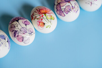 Easter beautiful decorated orthodox religious chicken eggs lie in a row on a blue background with space for text