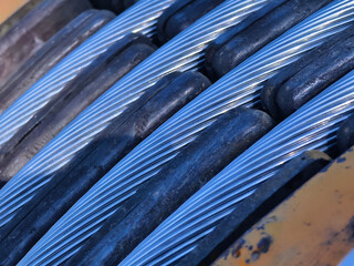 A large wooden spool of high-voltage electric wires is located on the road