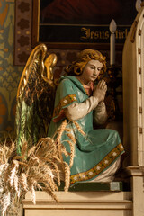 A praying angel with golden wings in a church