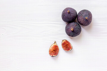 Whole and cut fresh ripe figs on wooden table. Top view