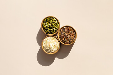 Organic Superfood Trio. Pumpkin Seeds, Flax, Sesame in Rustic Wooden Bowls.