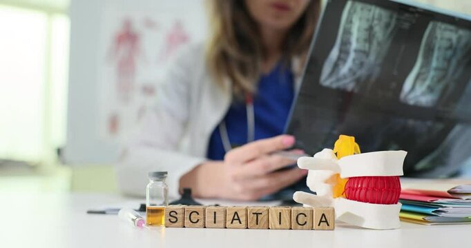 A doctor carefully reviewing Xrays while discussing the condition of sciatica with a concerned patient