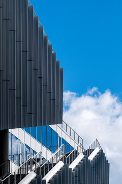 Contemporary building with layered metal elements and blue sky background.