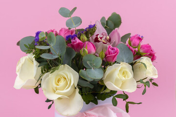 Beautiful bouquet of rose and orchid in vase blossoms on a pink background