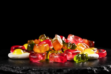 Assorted colorful gummy candies. Jelly sweets on stone plate