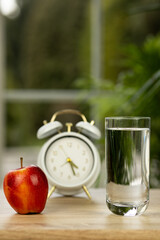 An apple and a glass of water on the table. Treatment of vitamin deficiency