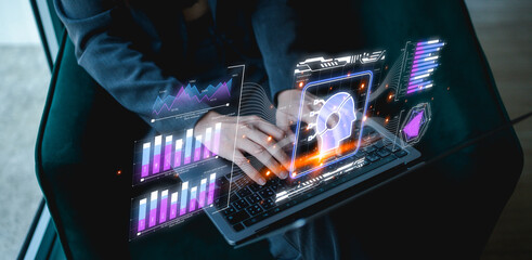 A person interacts with a futuristic laptop displaying holographic data and visualizations, including a skull, representing technology and information processing.
