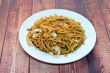 A plate of noodles with meat and vegetables