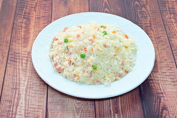 A plate of rice with vegetables and meat on top