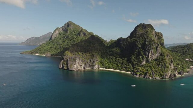 Drone flight over Corong Corong Beach with boats along the shore, offering a scenic view of the beach and Las Cabanas in the distance.
