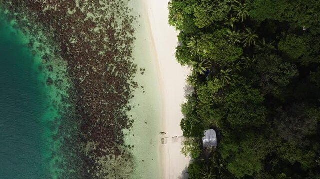 Drone flight over Corong Corong Beach with boats along the shore, offering a scenic view of the beach and Las Cabanas in the distance.
