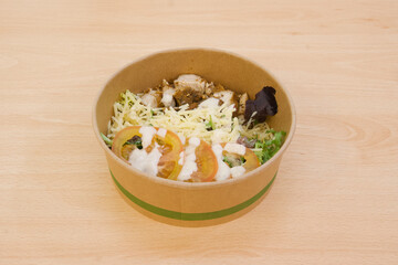A bowl of food with a green rim and a white sauce