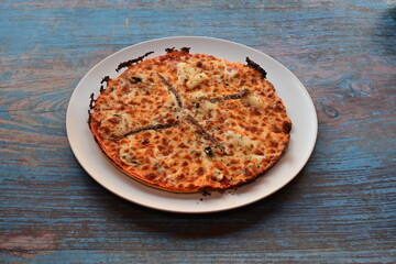 A pizza with cheese and pepperoni on a white plate