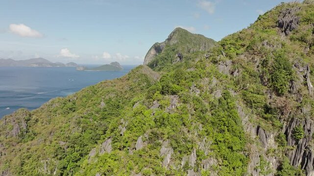 Drone flight over Corong Corong Beach with boats along the shore, offering a scenic view of the beach and Las Cabanas in the distance.
