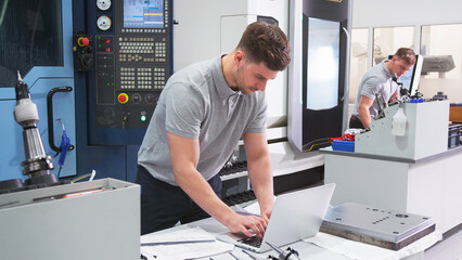 Male Engineer In Factory Using CAD Programming Software On Laptop