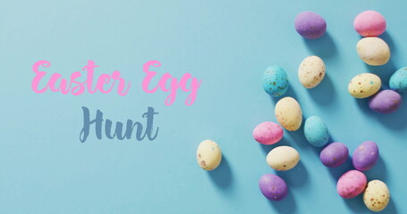 Fototapeta premium Image of easter egg hunt and happy easter text over blue background
