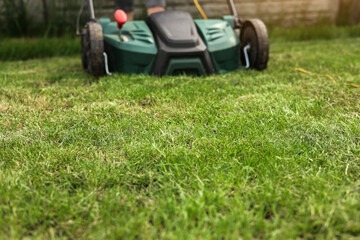 Gardening work tools. Green electric aerator scarifier for soil cultivation and compaction on...