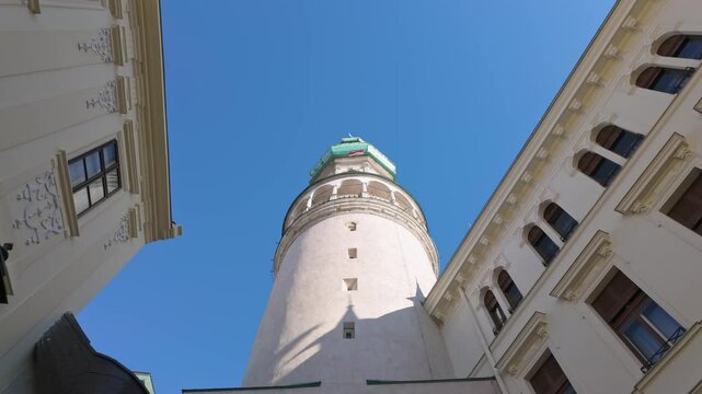 Bottom view of the Sopron Fire Tower with the Hungarian flag flying against the clear blue sky in the background in Hungary.