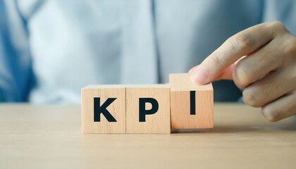 Naklejka premium A hand adjusting KPI blocks on a table, symbolizing performance measurement.