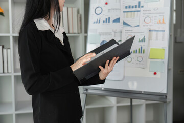 Businesswoman analyzing financial data and reports in a modern office setting.