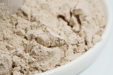 Protein powder in a measuring spoon. Bodybuilding, fitness and lifestyle in the gym. The concept of sports, health and nutrition	
