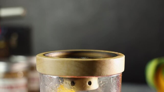 Woman adding wood cheps in glass jar