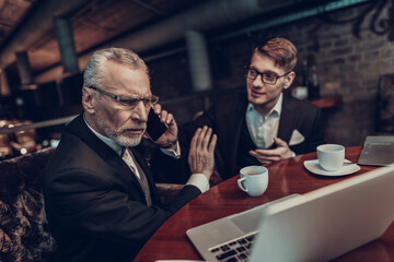 Old Man talking on Phone on Business Meeting