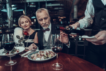 Waiter pours wine and Businessman stops him