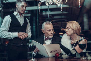 Couple makes an order to Waiter in Restaurant.
