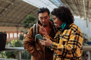 Tourists using smart phone app for navigating in train station, madrid