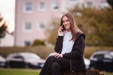 Fototapeta premium Young Woman Talking on the Phone Outdoors
