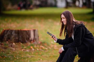 Young Woman Checking Smartphone in a Park